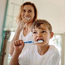 Mother and son brushing teeth together