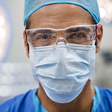 Implant dentist in Virginia Beach wearing a mask and scrubs