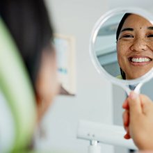 Woman smiling at herself in the mirror