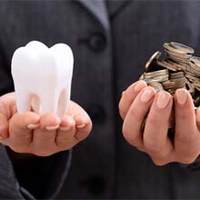 Tooth and coins in palms of hands