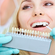 Woman having the shade of her tooth matched