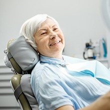 gray-haired woman admiring her smile with dentures in Virginia Beach 