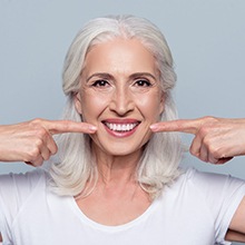 Older woman point to her smile