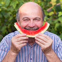 Man eating a watermelon to prevent dental emergencies in Virginia Beach