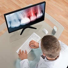 A dentist looking an X-ray of a damaged tooth.