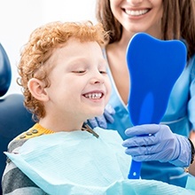 Little boy looking at smile in mirror