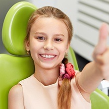 Smiling young girl in dental chair