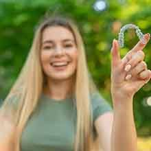 Teen girl holding clear aligner