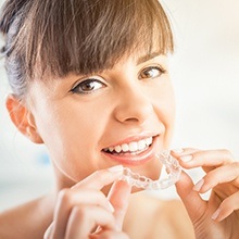 Woman placing Invisalign tray