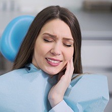 Woman holding cheek in pain