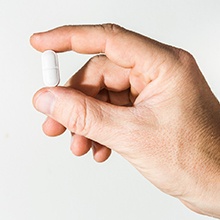 a person holding a pill used for oral conscious sedation