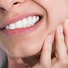 Closeup of patient holding jaw in pain