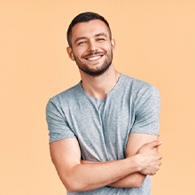 Man in grey shirt smiling with tooth-colored fillings