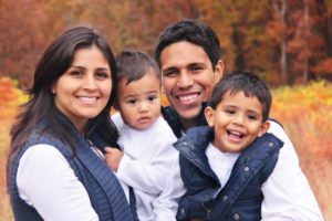 family of four smiling and hugging