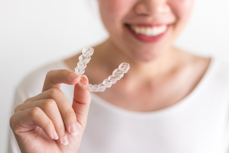 a woman holding Invisalign braces