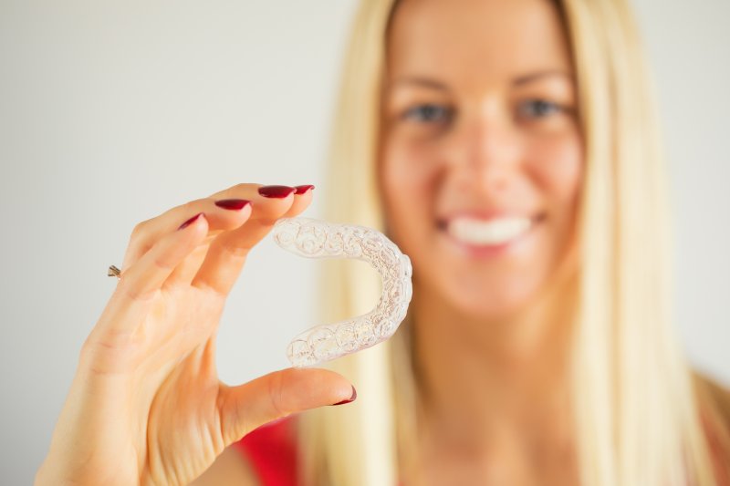 Woman holding her clear aligners