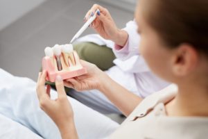 dentist showing patient a diagram of dental implants in virginia beach