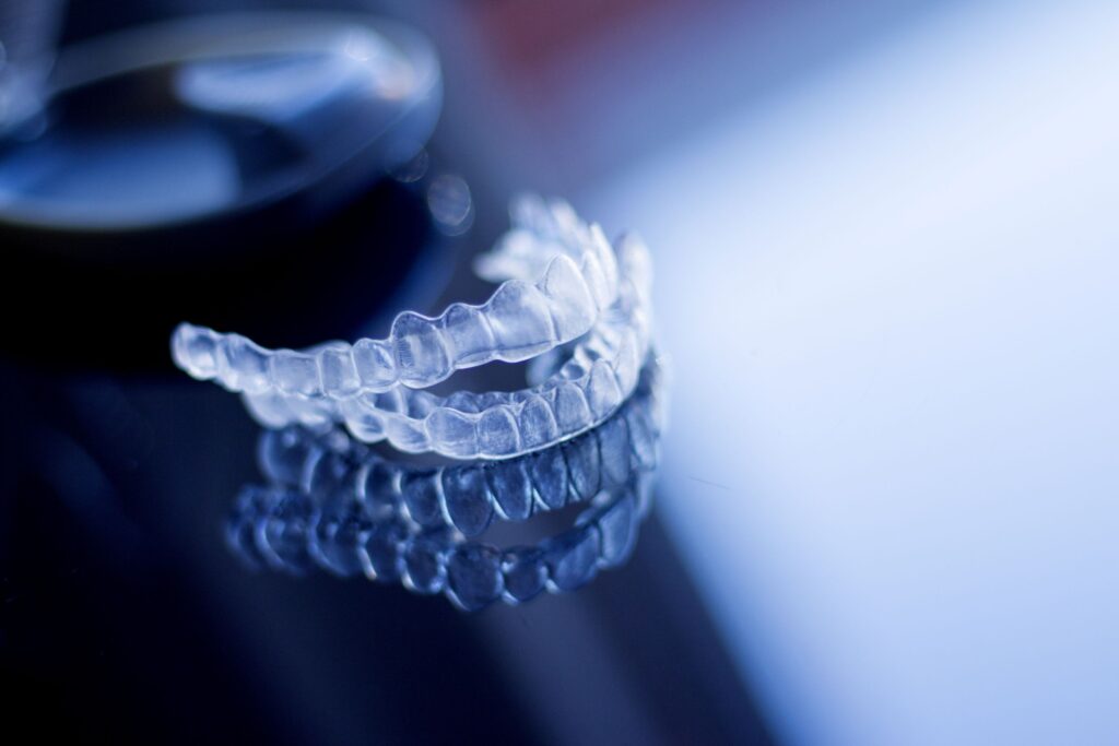 Clear aligners on dark, reflective surface